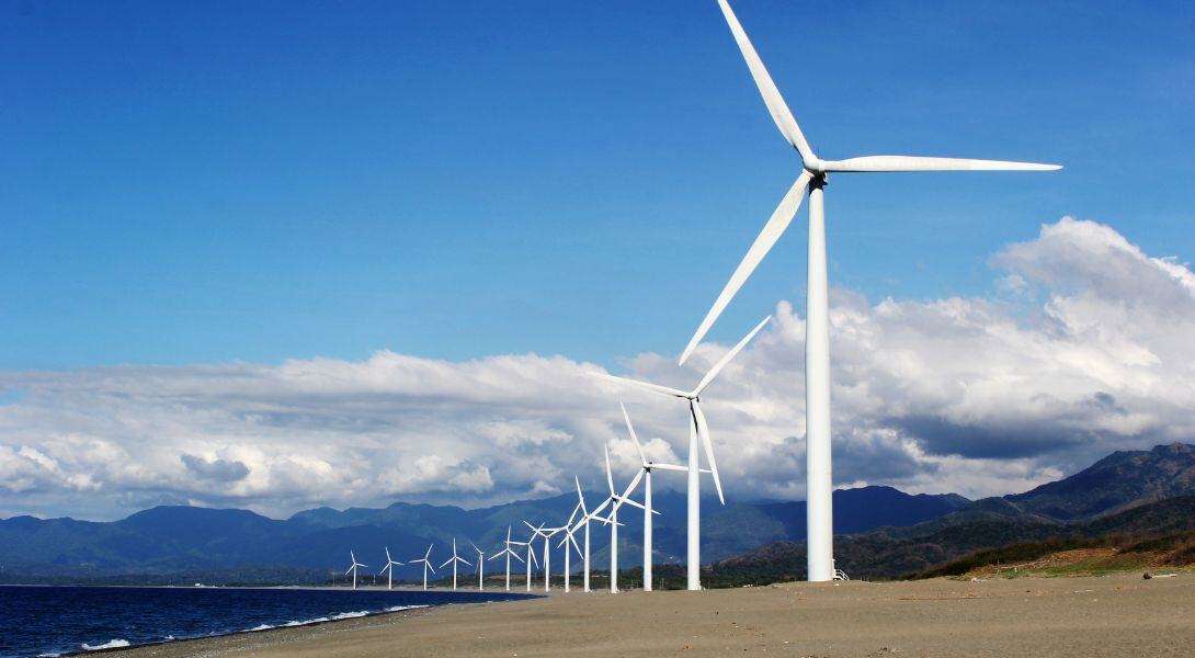 White Wind Turbines on Gray Sand Near Body of Water