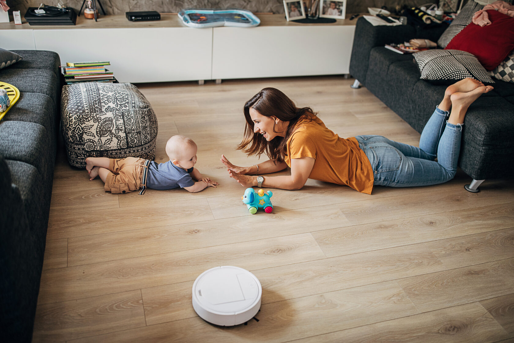 Mon and kid on floor with robot vacuum